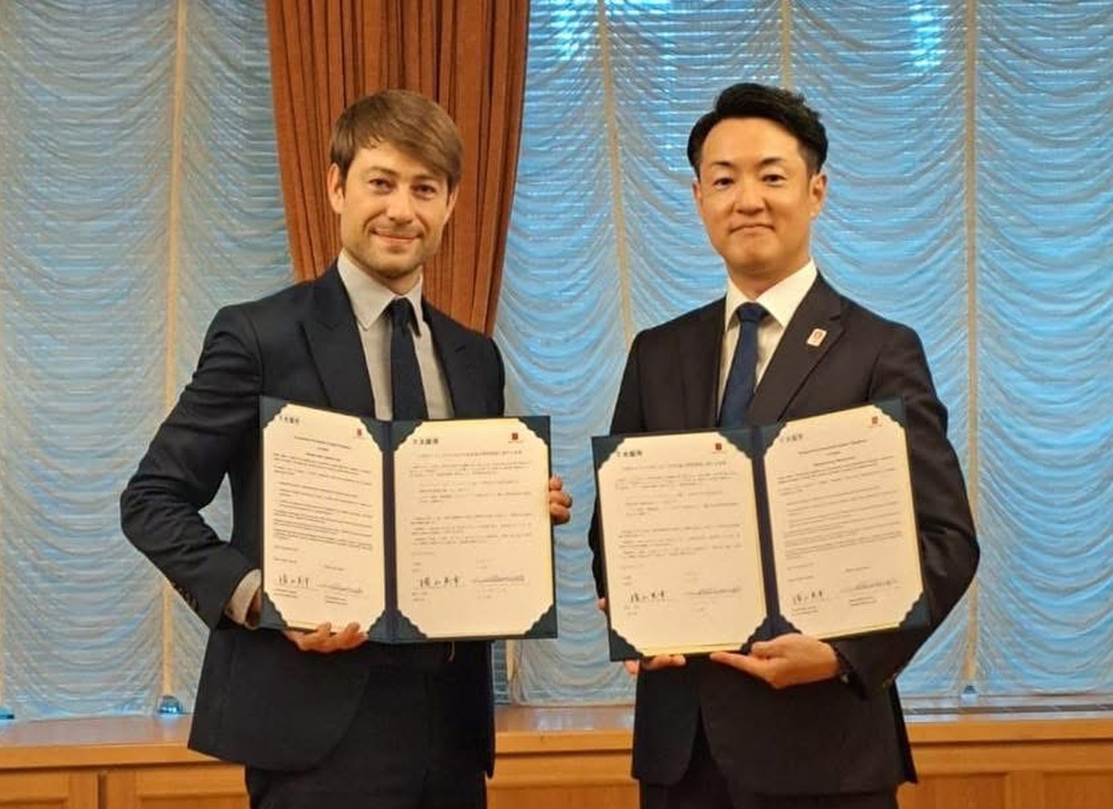 Adam Pustelnik, First Deputy Mayor of Łódź, and Hideyuki Yokoyama, Mayor of Osaka, holding the signed partnership memorandum